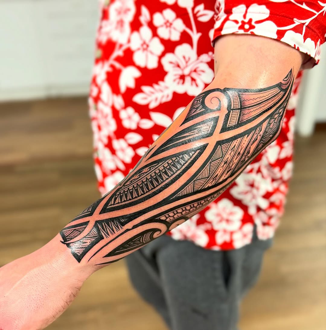 Bold Polynesian-inspired blackwork forearm sleeve with intricate geometry