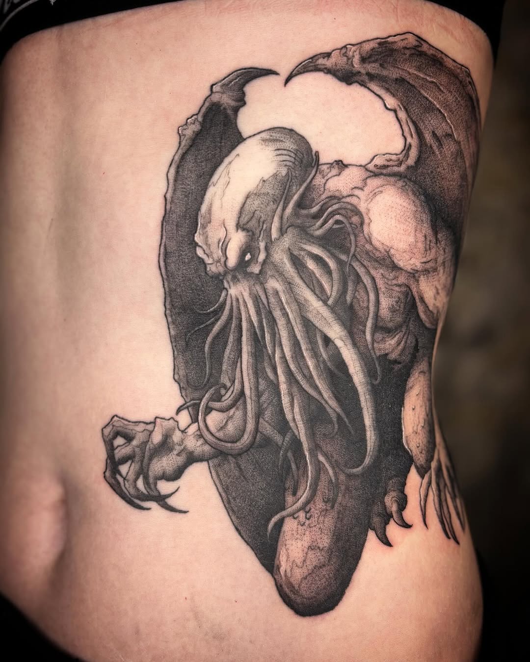 Monstrous Cthulhu rib tattoo in bold blackwork.