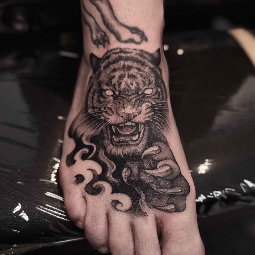 Bold black tiger head on the foot with smoky swirls