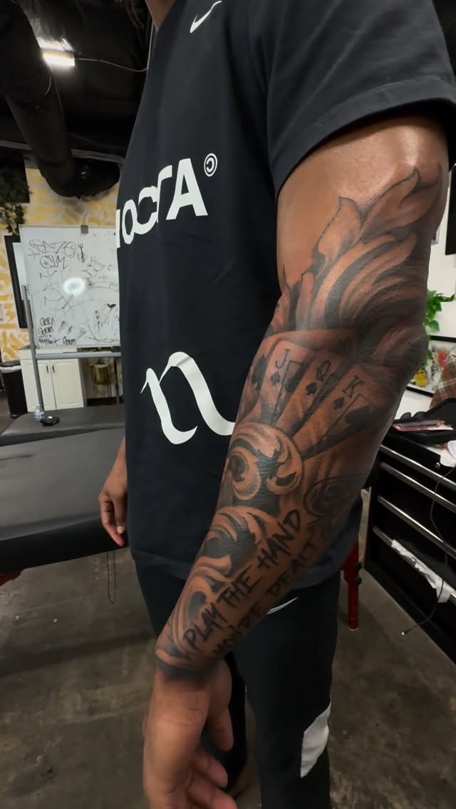 Bold black-and-gray forearm sleeve with ornamental scrollwork.