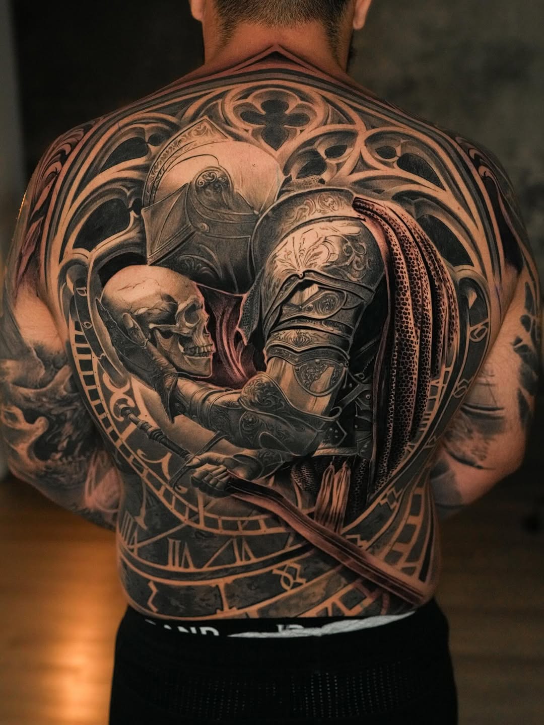 Intricate grayscale knight with skeletal skull within ornate frame