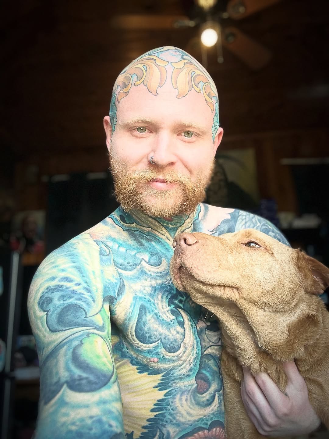 Bold watercolor waves swirl across chest, ornate scalp motif