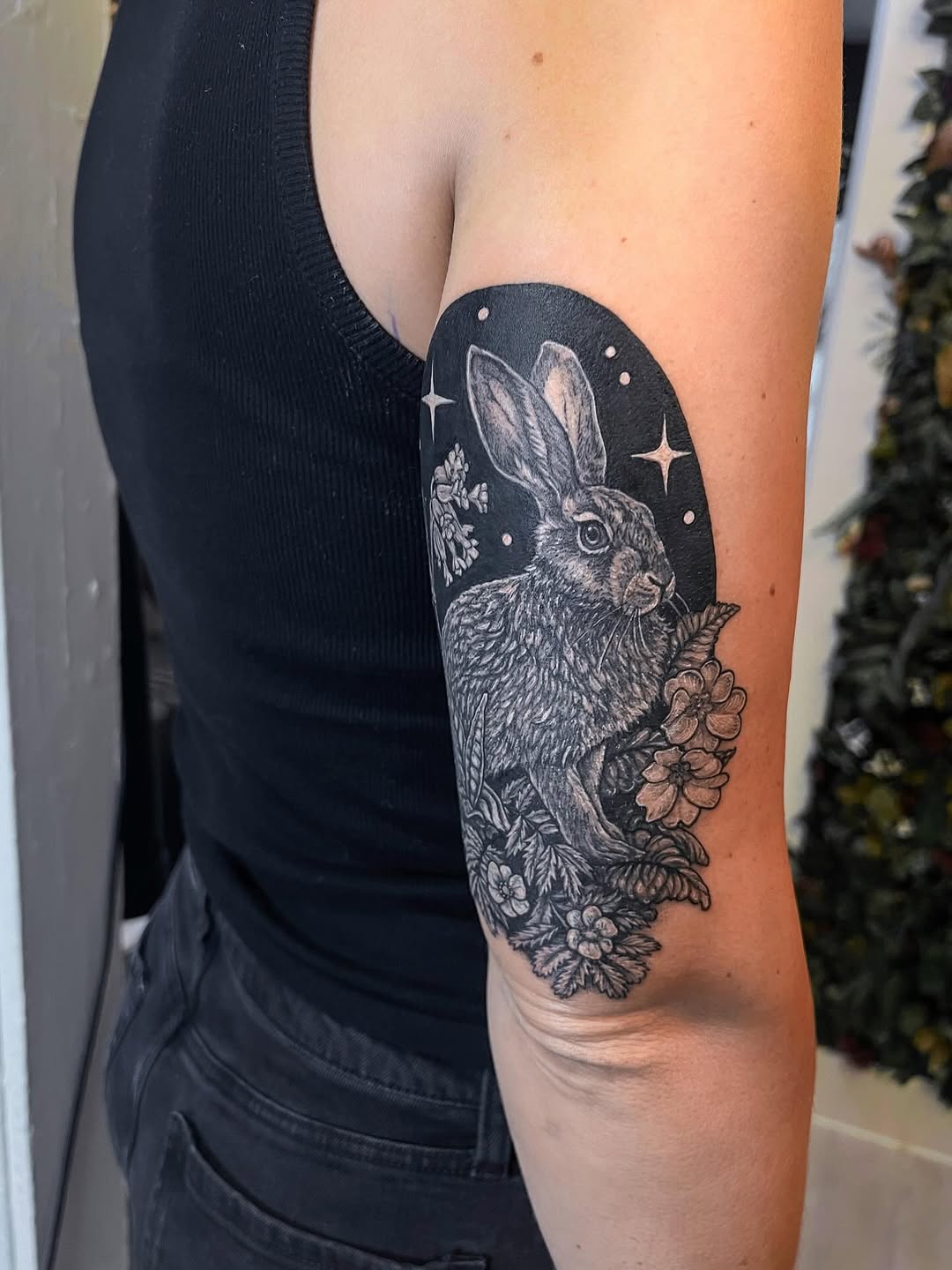 Illustrative blackwork rabbit among florals in lunar halo.