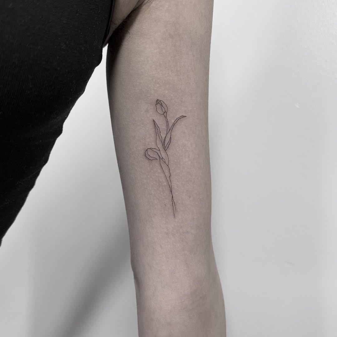 Delicate fine-line tulip on the forearm.