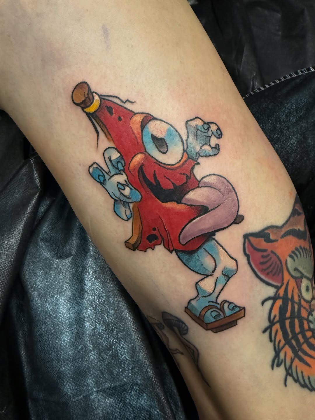 Bold cartoon sausage-creature with blue gloves, playful expression