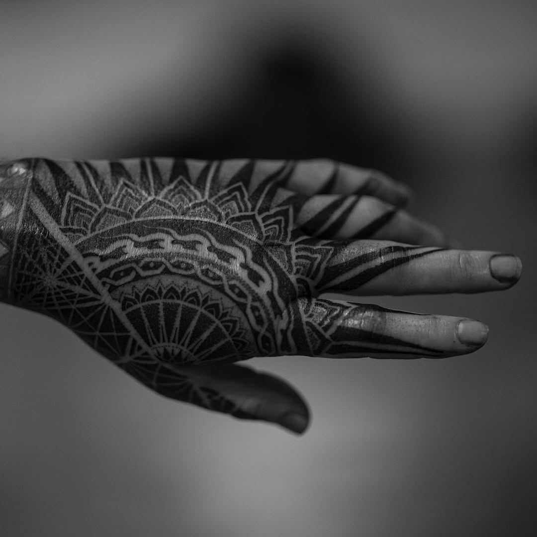 Intricate black geometric mandala spanning the back of the hand