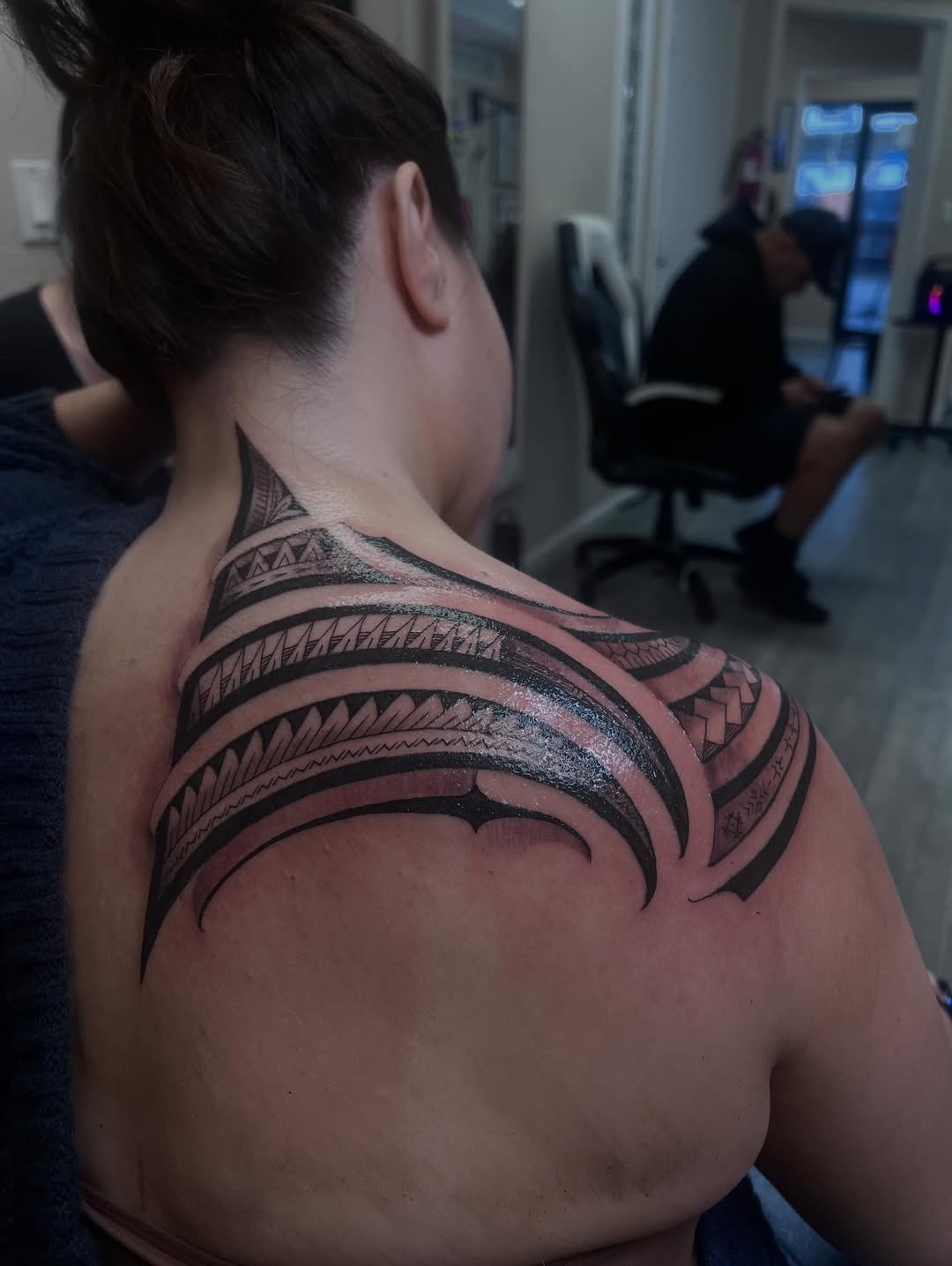 Bold Polynesian blackwork shoulder piece with geometric bands.