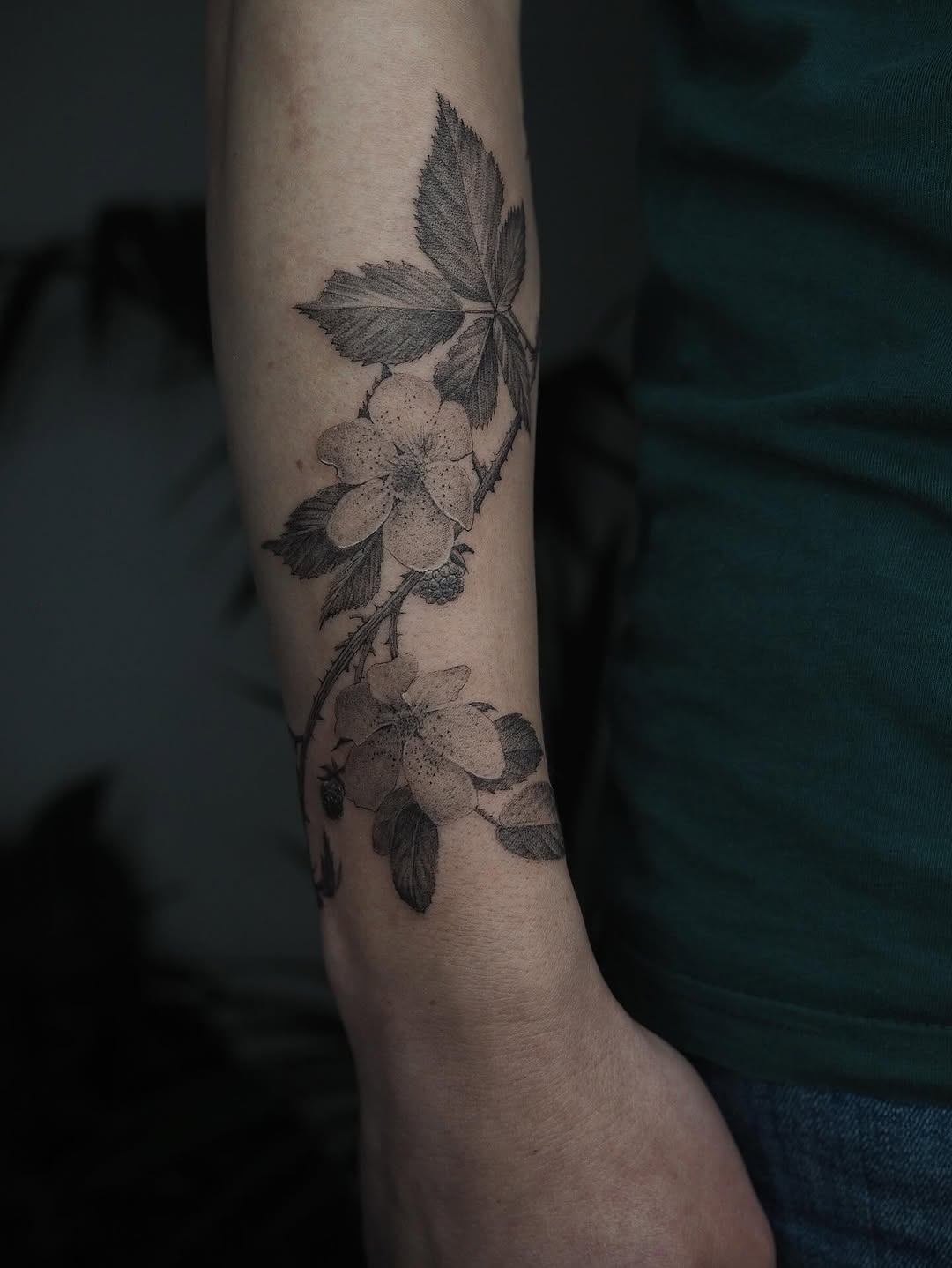 Delicate blackberry blossoms winding along a refined blackwork stem.