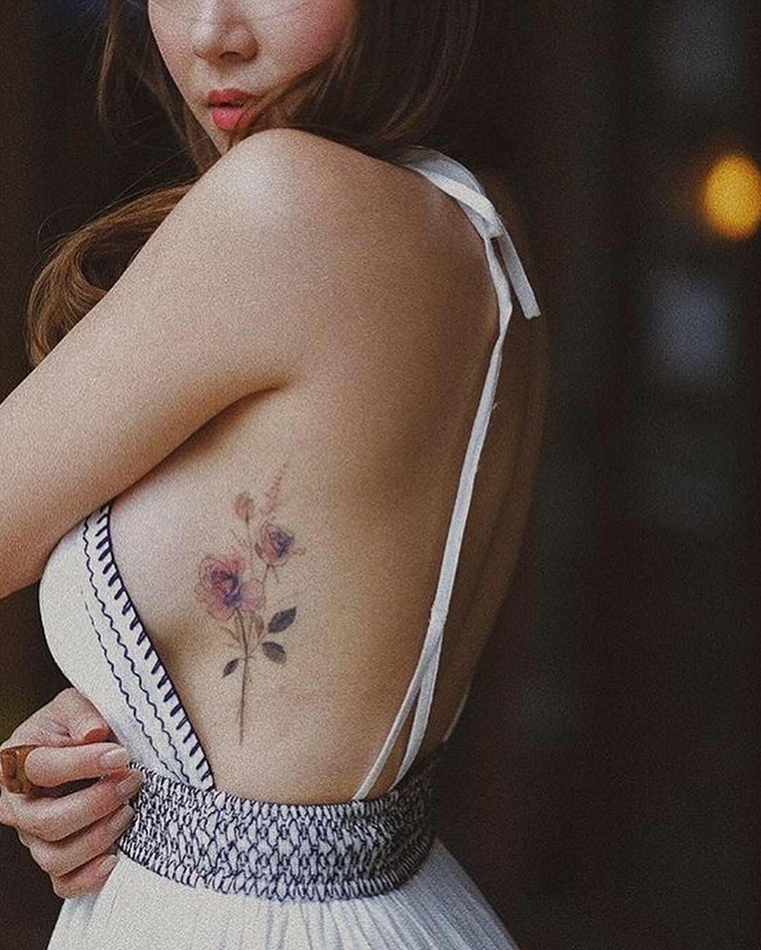 Delicate watercolor blossoms along shoulder with soft shading.