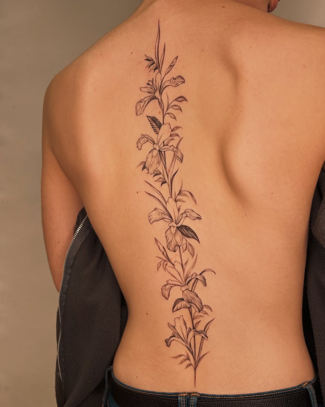 Delicate vertical botanical spine tattoo with irises