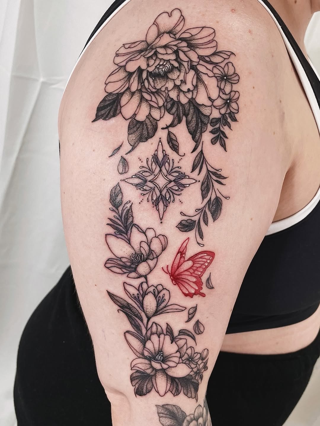 Cascading black floral bouquet with red butterfly accent