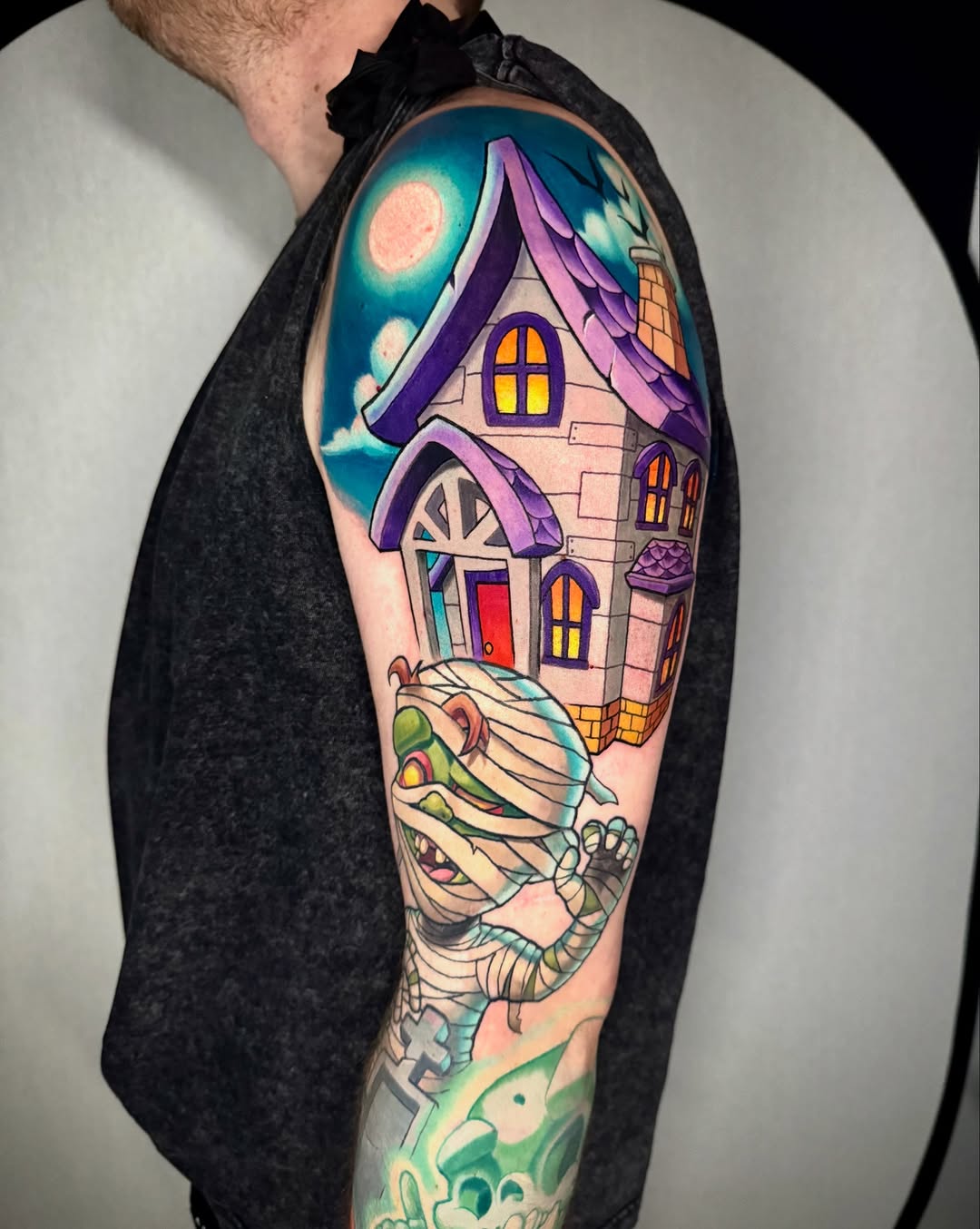 Vibrant cartoon haunted-house sleeve with purple rooftops and glowing windows.