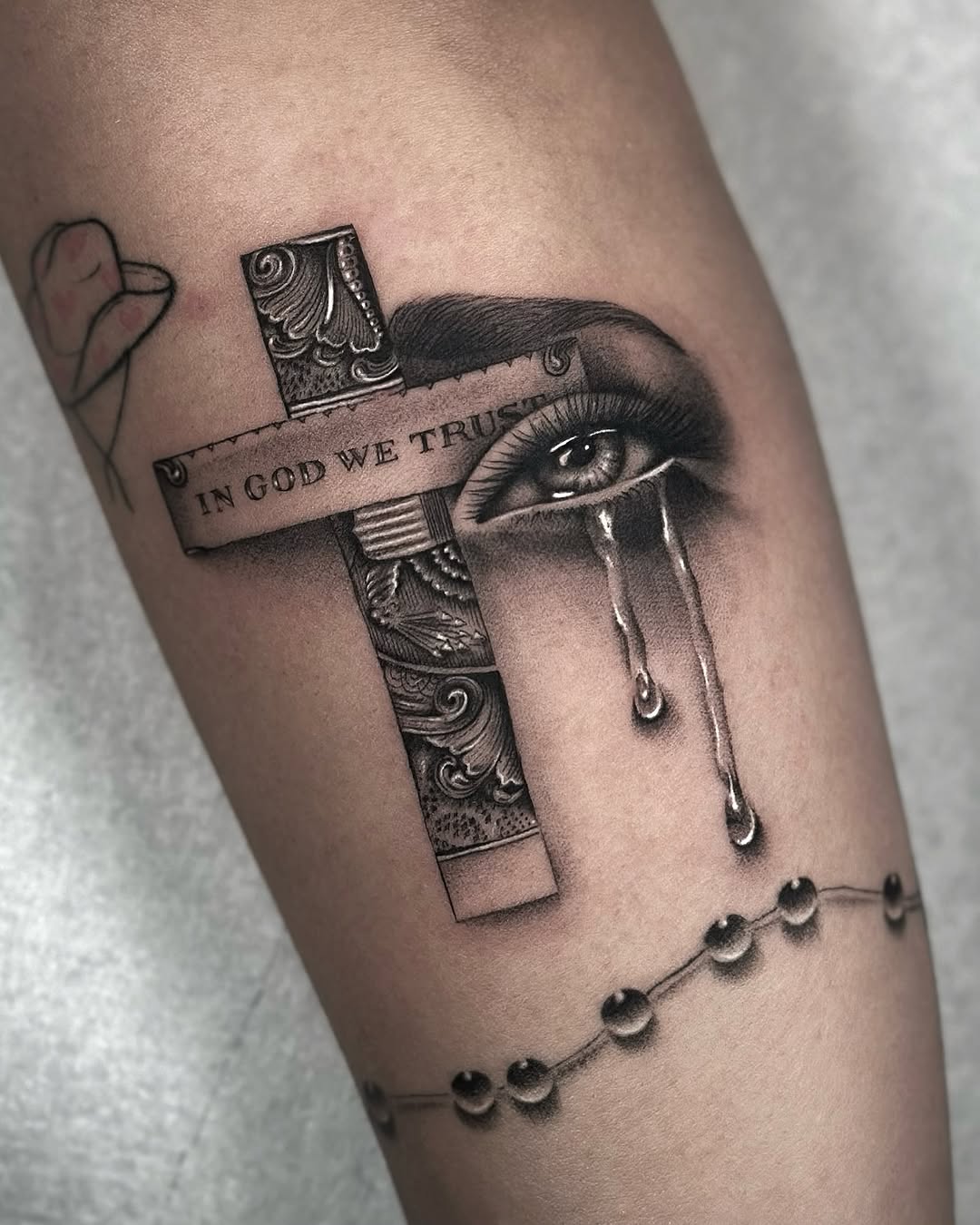 Intricate grayscale cross with banner, eye motif, beads