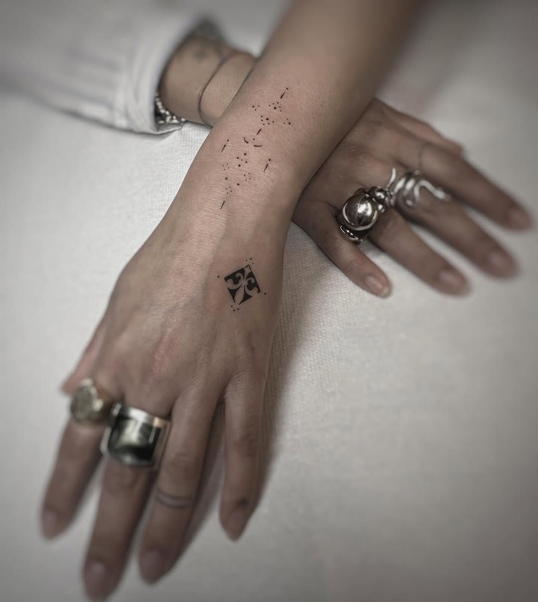 Tiny black diamond ornament with dotted accents.