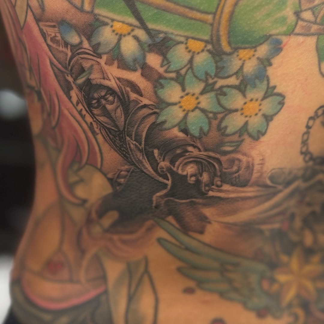 Blue forget-me-nots frame a grayscale hooded warrior.