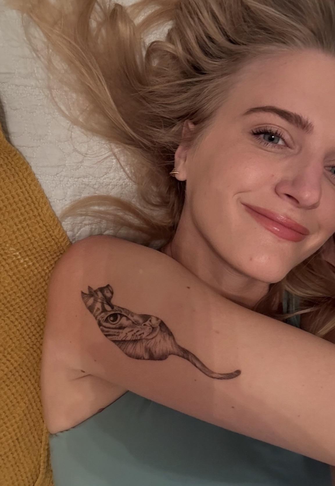 Whimsical striped whale-like creature with curling tail on shoulder