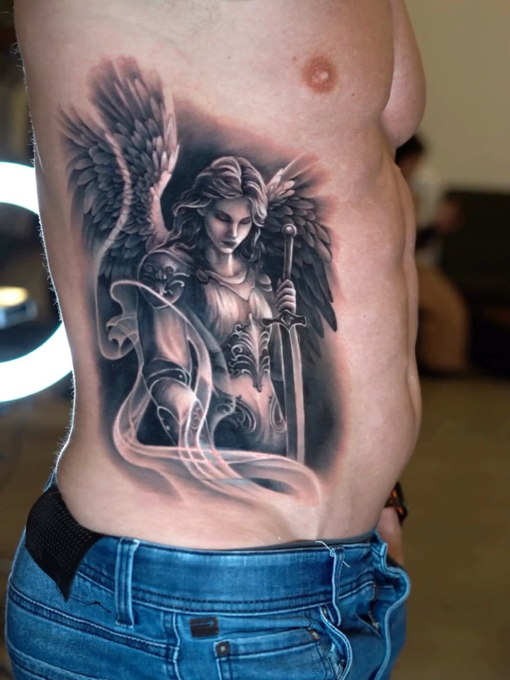 Majestic grayscale angel with flowing wings and sword