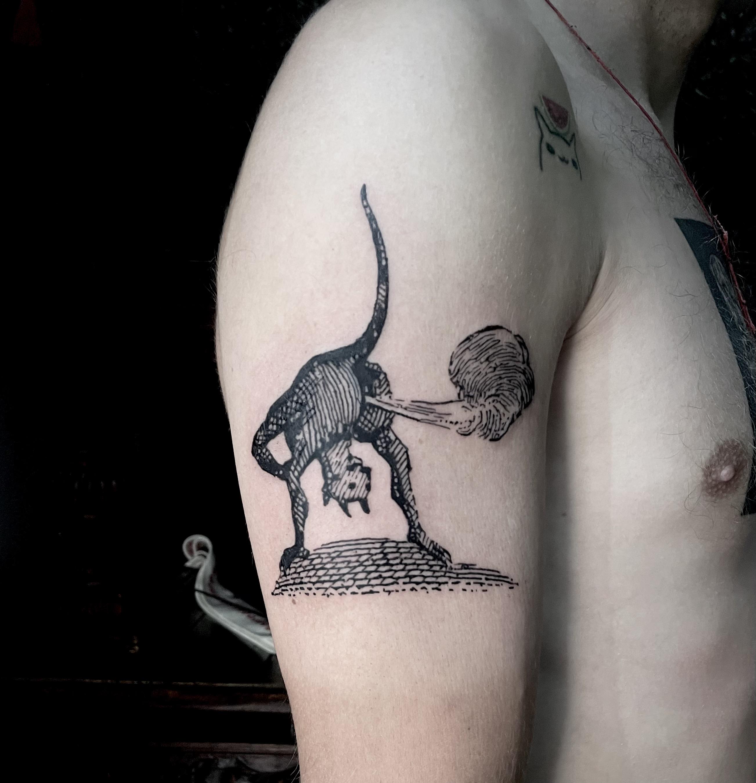 Engraving-style beast on upper arm with arcing tail.