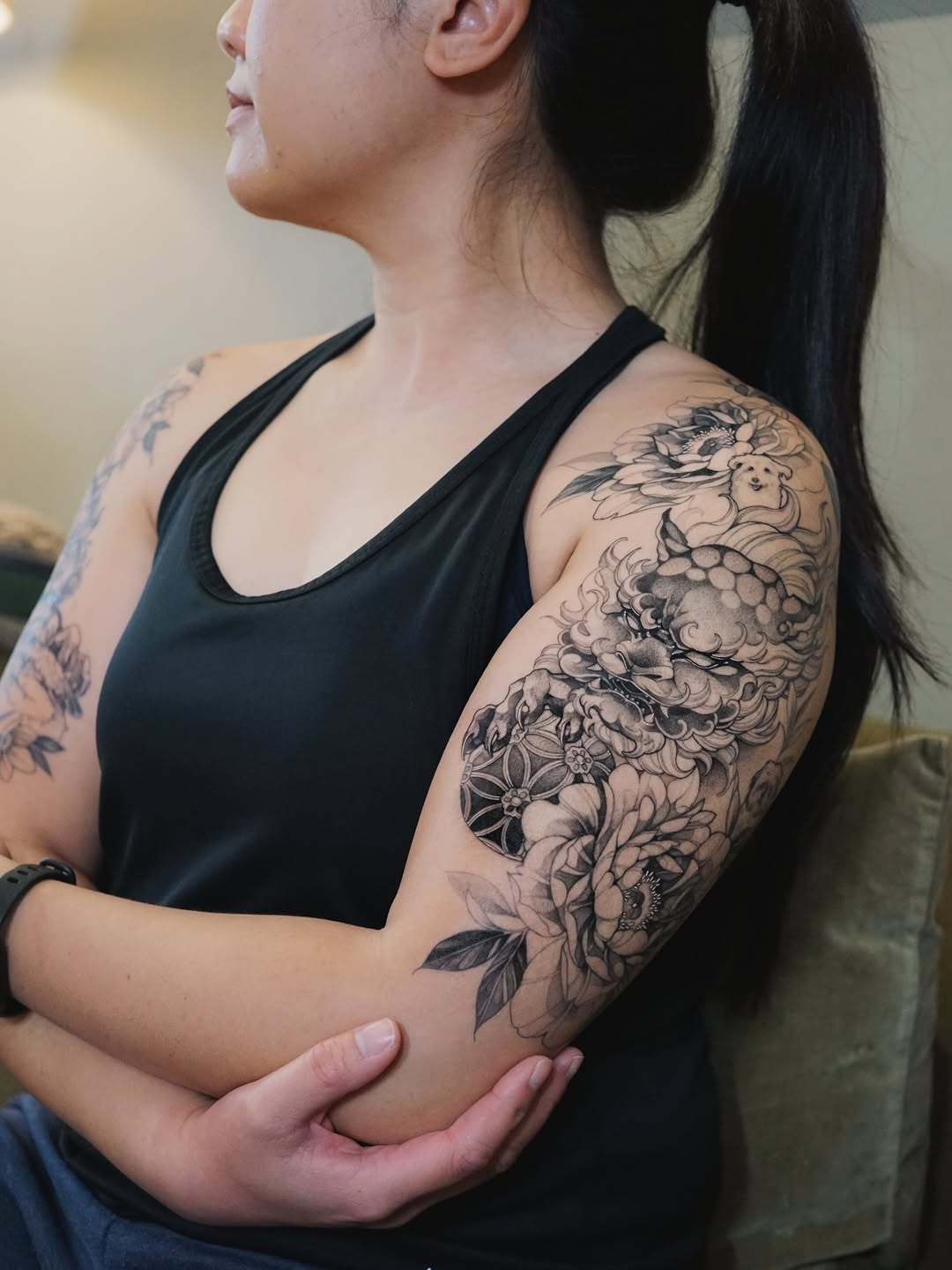 Elegant black-and-gray fu dog amid floral sleeve