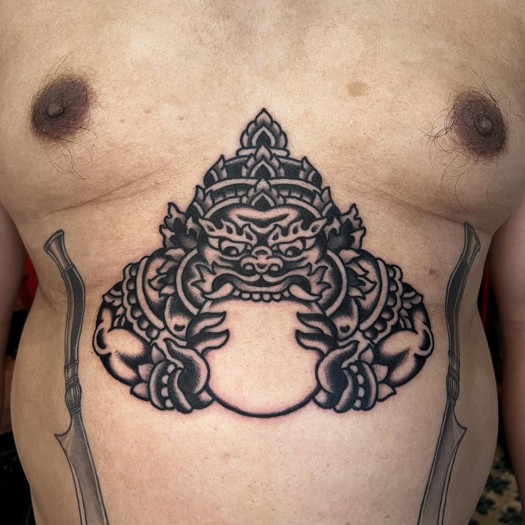 Bold demon mask with ornate crown centered on the chest