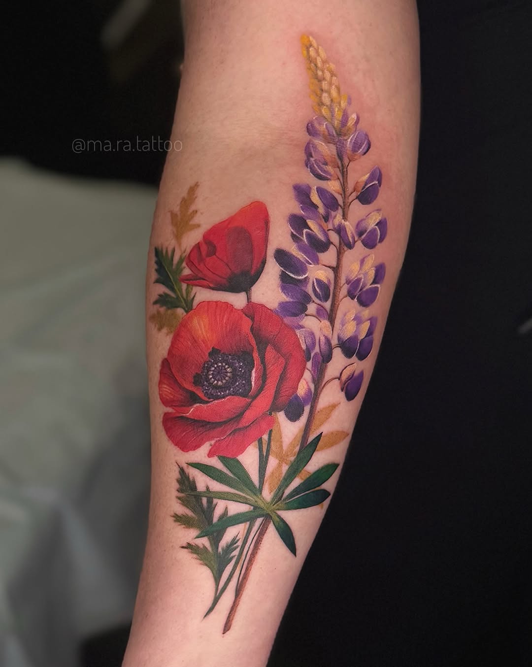 Vibrant botanical forearm tattoo of red poppies and purple lupines