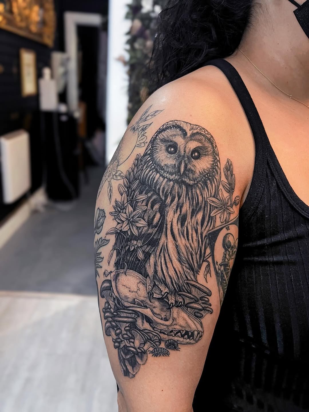 Owl portrait perched over fox skull amid florals.