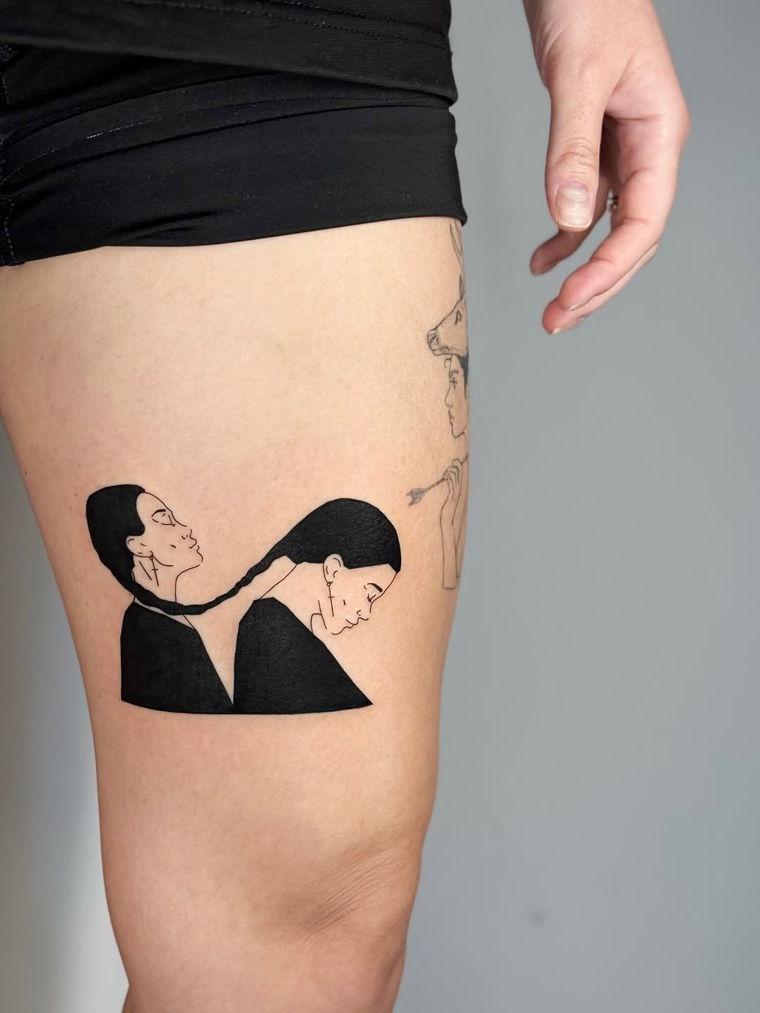 Bold black silhouette figures connected by braided hair