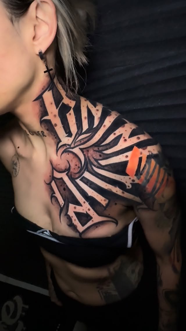 Bold blackwork radial geometric pattern across shoulder and chest