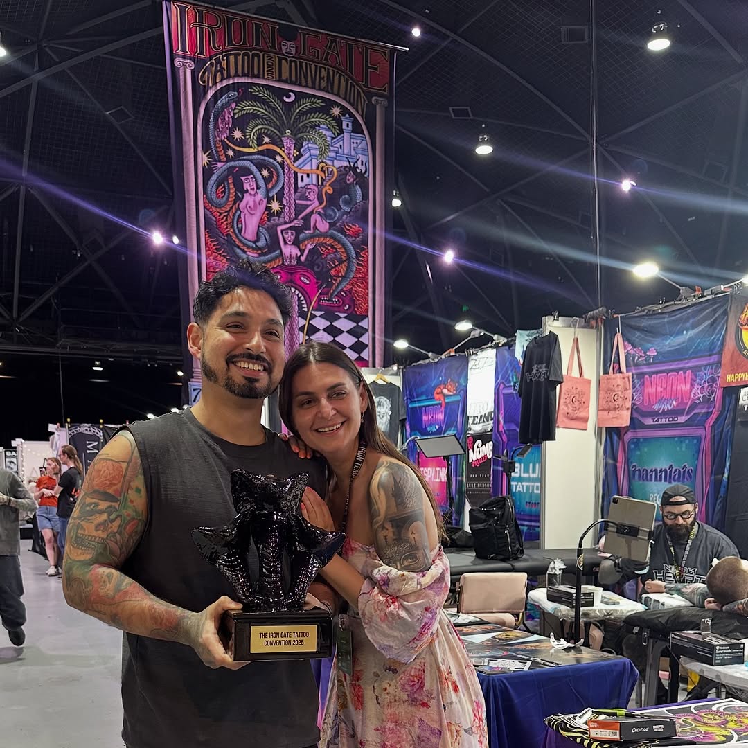 Joyful duo with trophy at Iron Gate Tattoo Convention.