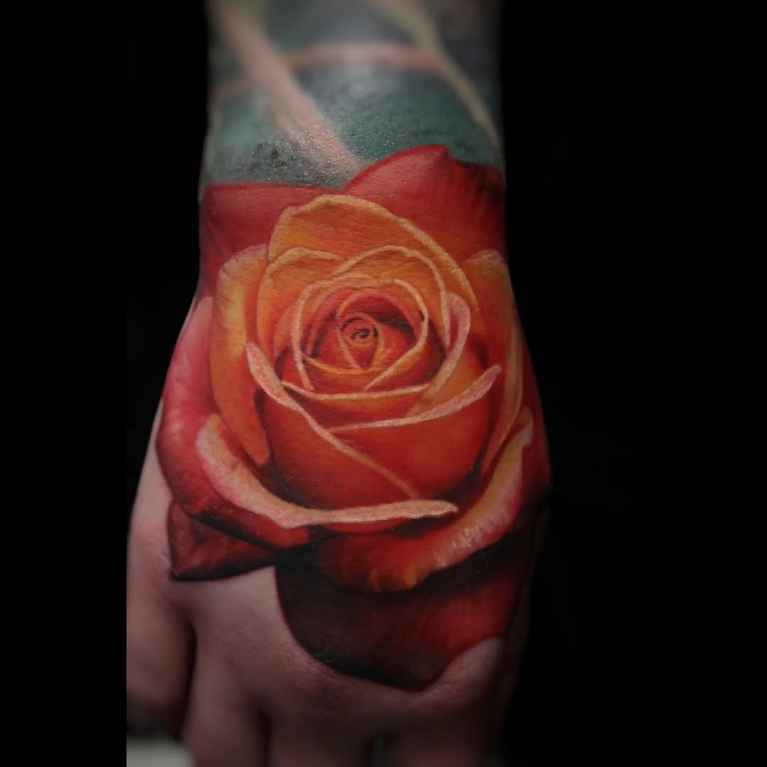 Hyper-realistic orange-red rose on forearm with watercolor shading