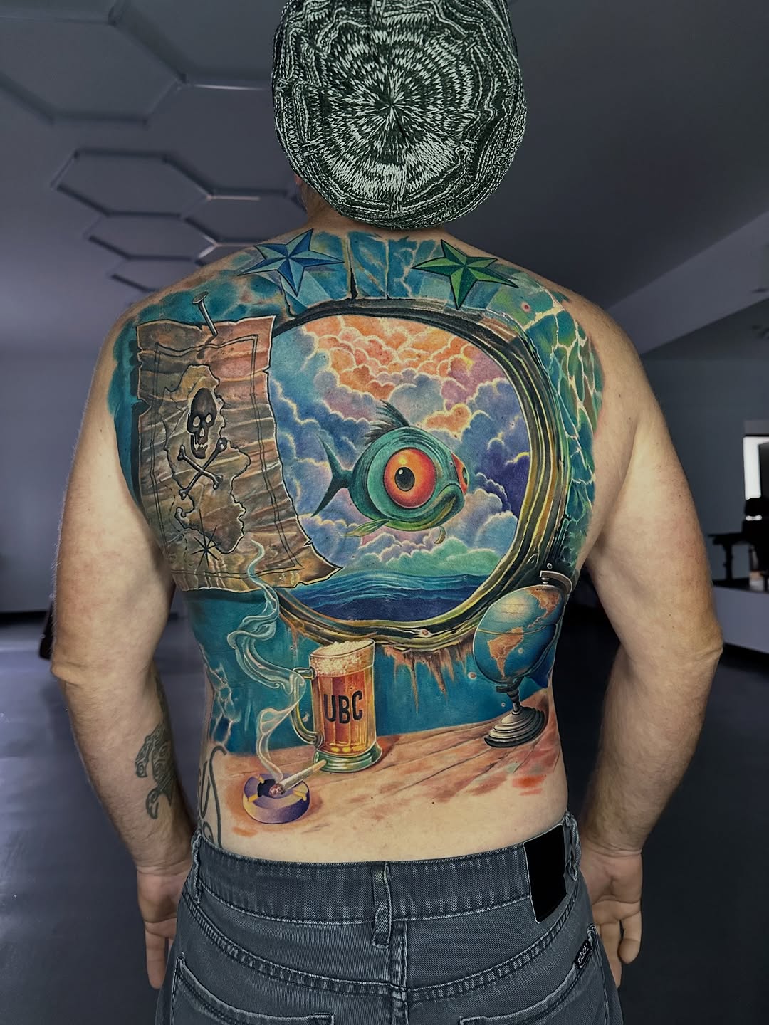 Vibrant neo-traditional back piece with surreal aquatic scene.