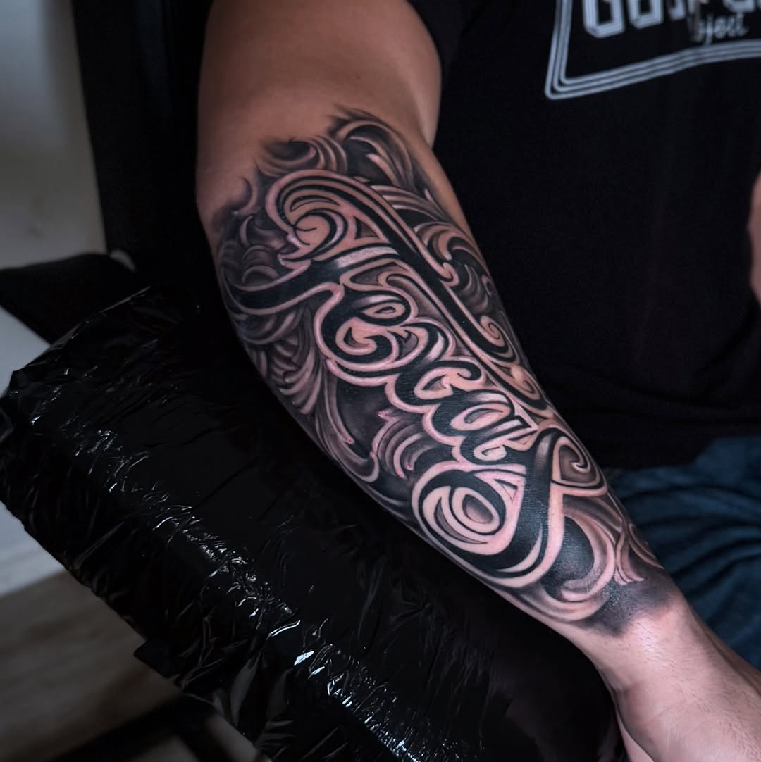 Intricate blackwork forearm sleeve with swirling ornamental patterns.