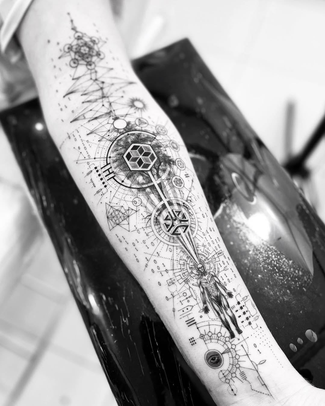 Intricate geometric biomechanical forearm tattoo with cosmic motifs