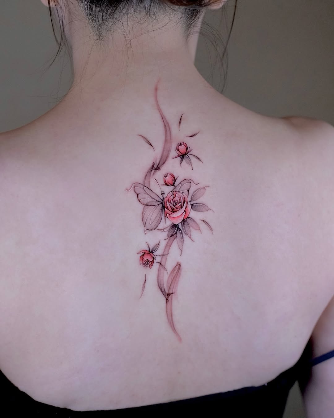 Delicate fine-line roses with a fluttering butterfly along spine