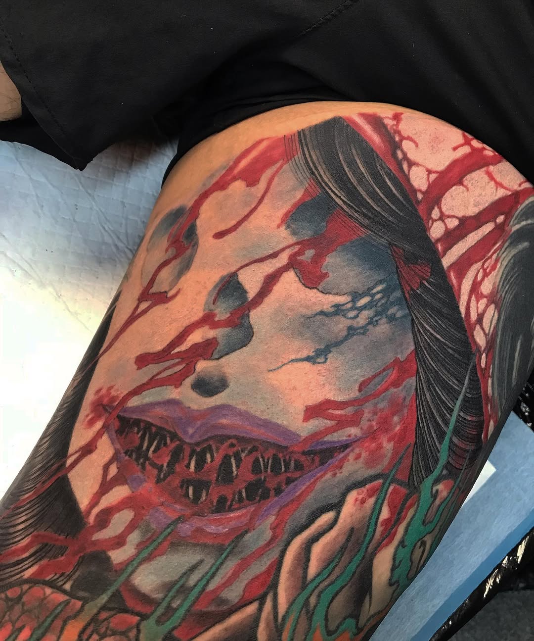 Menacing creature-mouth with jagged teeth, red splashes, and dark hair