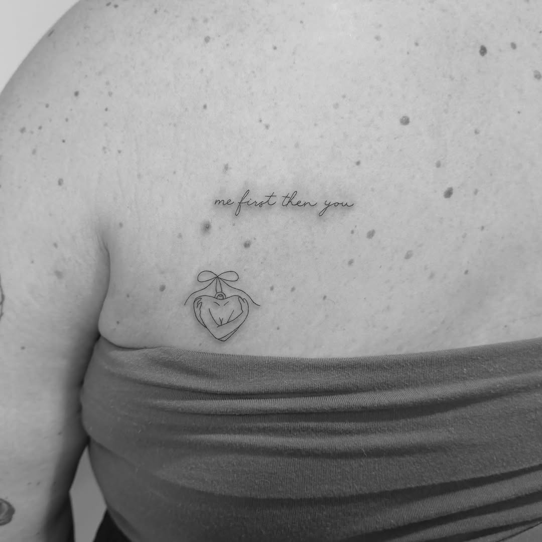 Delicate cursive phrase 'me first then you' with a heart-locket.