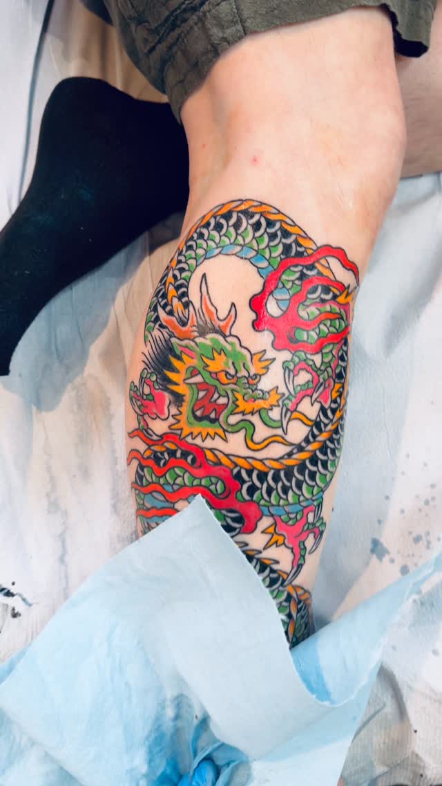 Bold multicolor dragon with emerald scales and fiery ribbons.