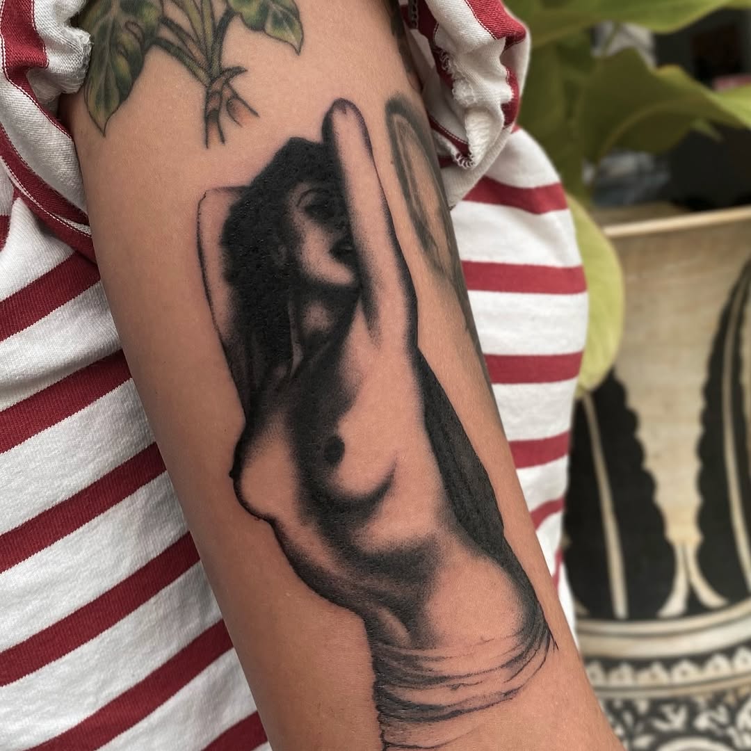 Bold black silhouette of a reclining nude female torso.