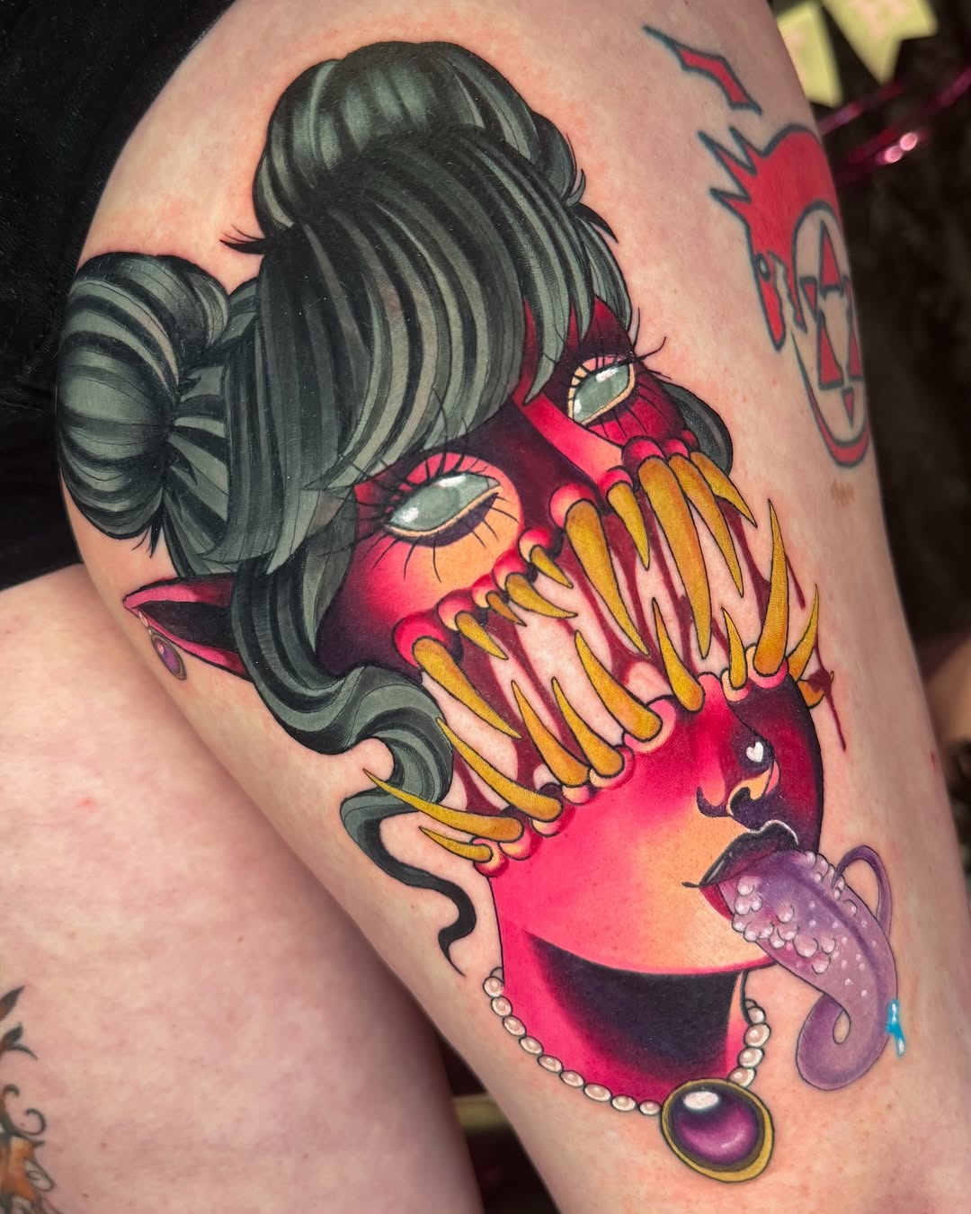 Bold neo-traditional demon-siren portrait with fanged grin.