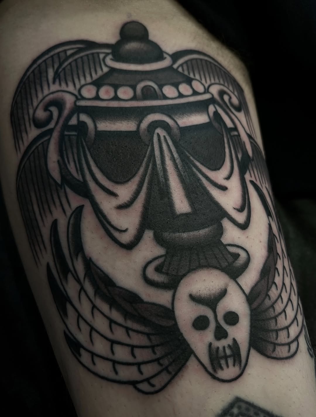 Bold black-ink UFO with winged skull and dramatic shading