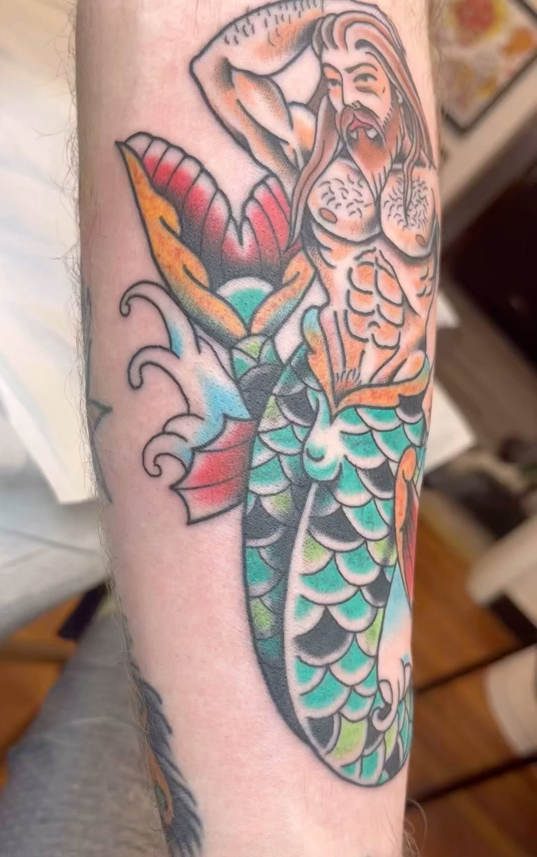 Bold traditional Poseidon-merman with vibrant scales and fins