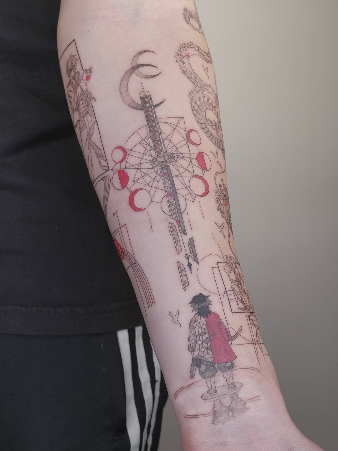 Intricate anime-inspired forearm tattoo with geometric sword and lunar motifs