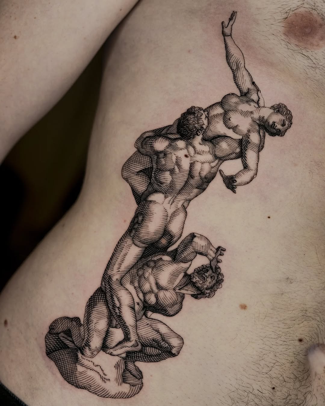 Engraved-style two-figure sculpture relief with twisting, dynamic poses