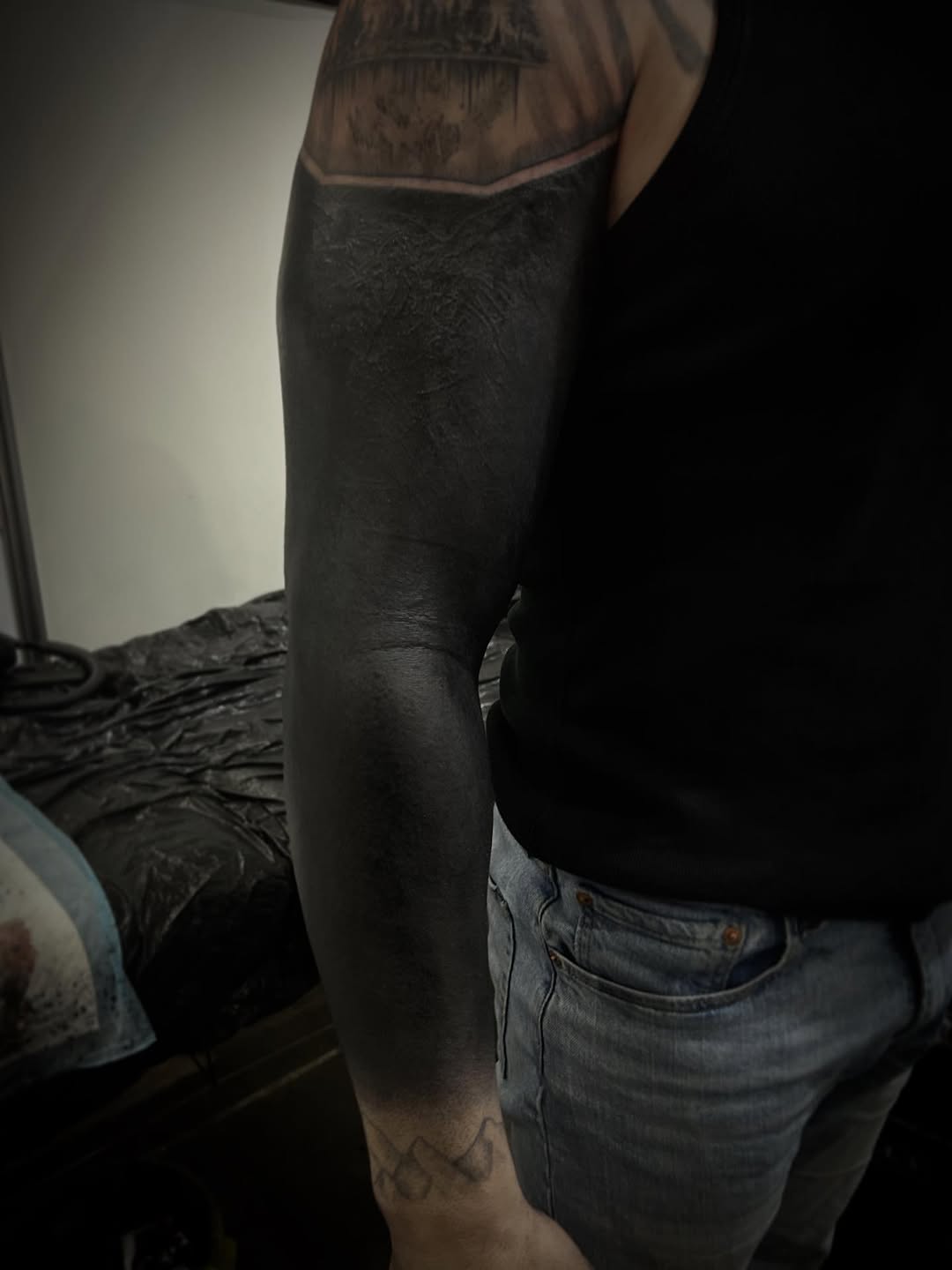 Solid black blackout forearm sleeve with subtle texture.