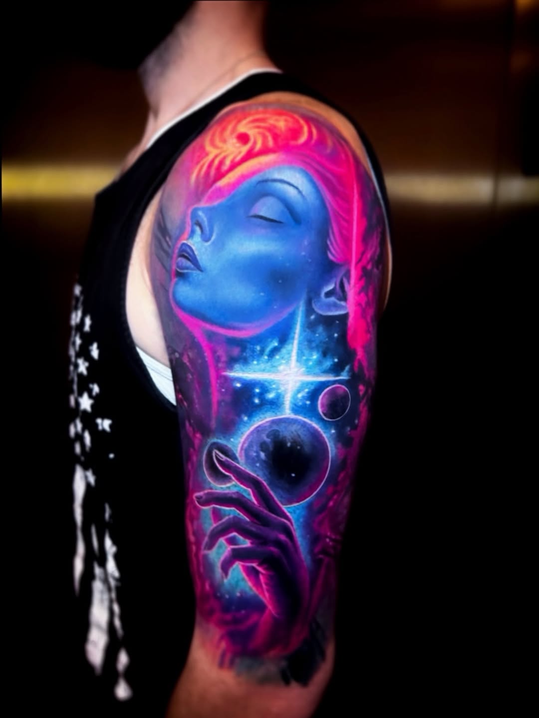 Vivid neon cosmic portrait on the upper-arm sleeve.
