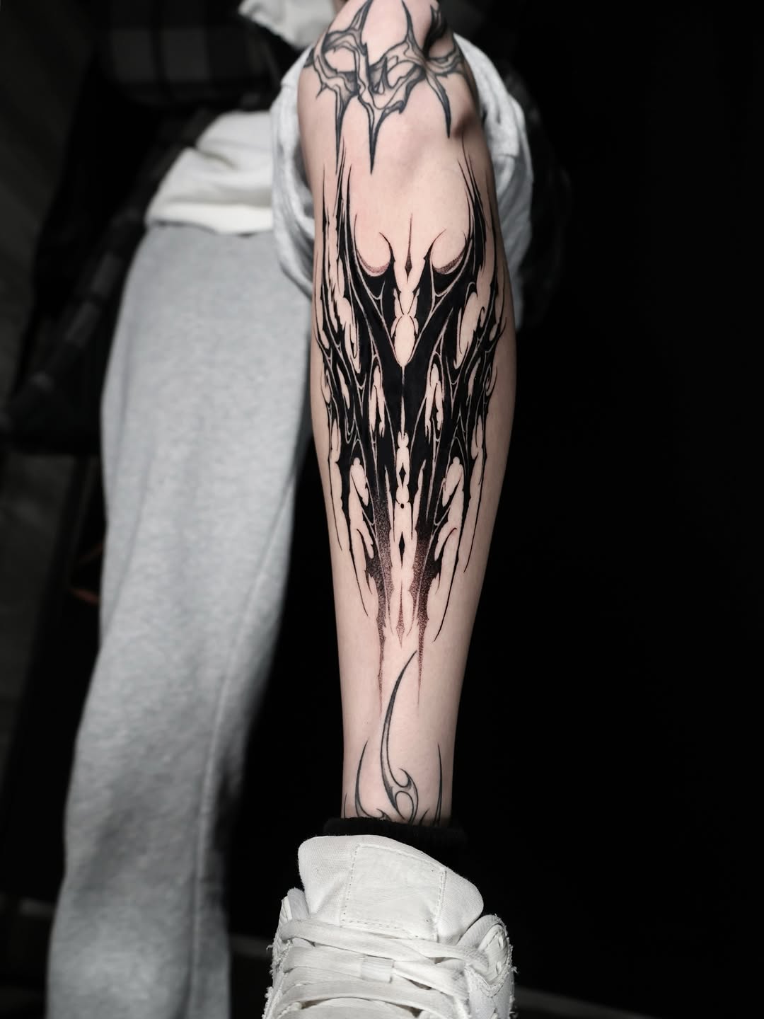 Dramatic blackwork forearm piece with symmetrical, spire-like forms.