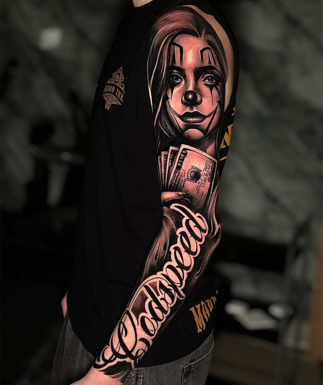 Bold black-and-gray clown portrait with ornate script