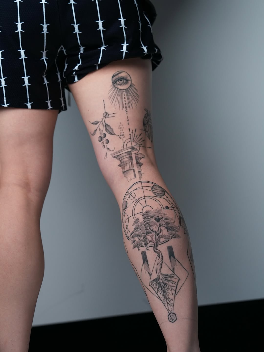 Intricate black-and-gray leg piece with celestial-botanical motifs