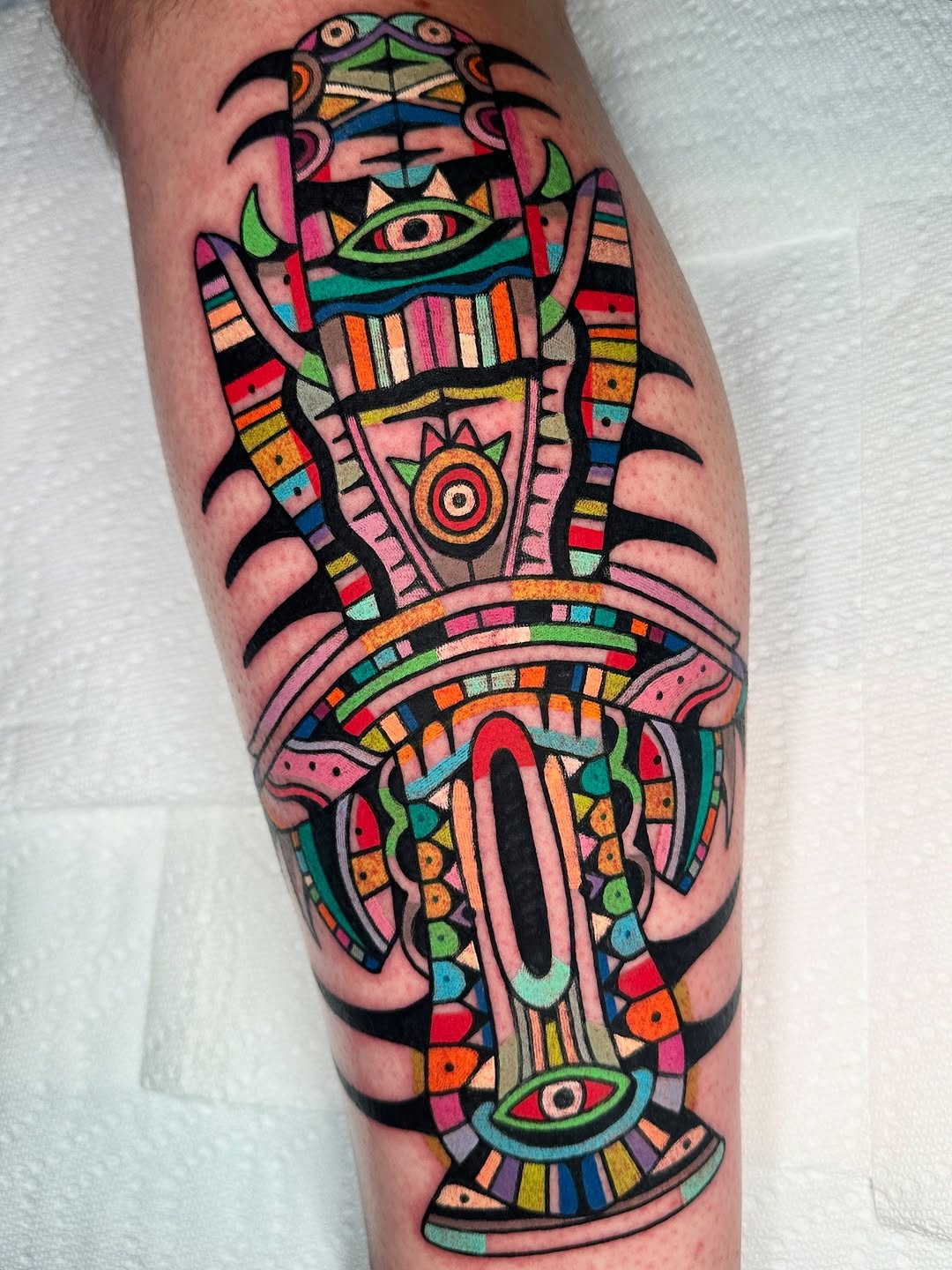 Vibrant geometric totem with kaleidoscopic eyes and panels