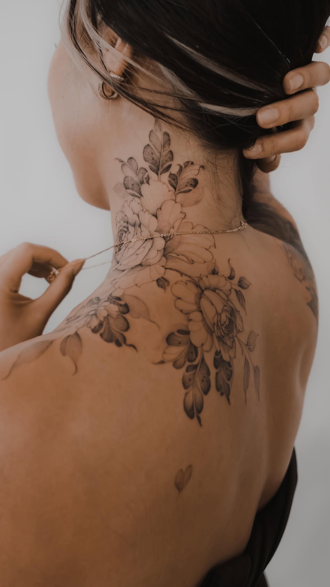 Delicate fine-line floral collar along the neck